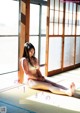 A woman sitting on the floor in front of a window.