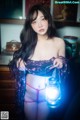 A woman in lingerie holding a lantern in her hand.