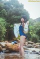 A woman in a blue bathing suit standing in a river.