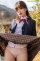 A woman in a school uniform is posing for the camera.