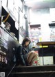 A woman sitting on the steps of a building.