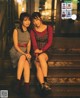 Two young women sitting on the steps of a building.