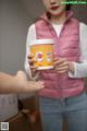 A woman holding a cup of ice cream in her hand.