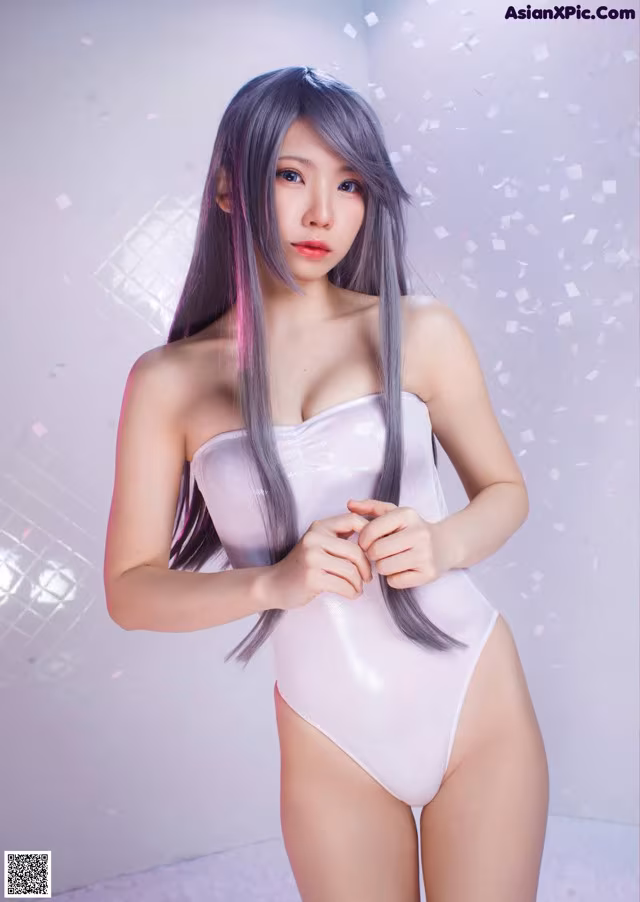 A woman in a white bodysuit posing for a picture.