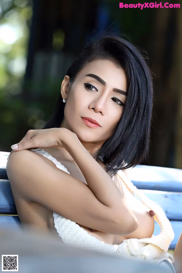 A woman sitting on top of a blue bench.